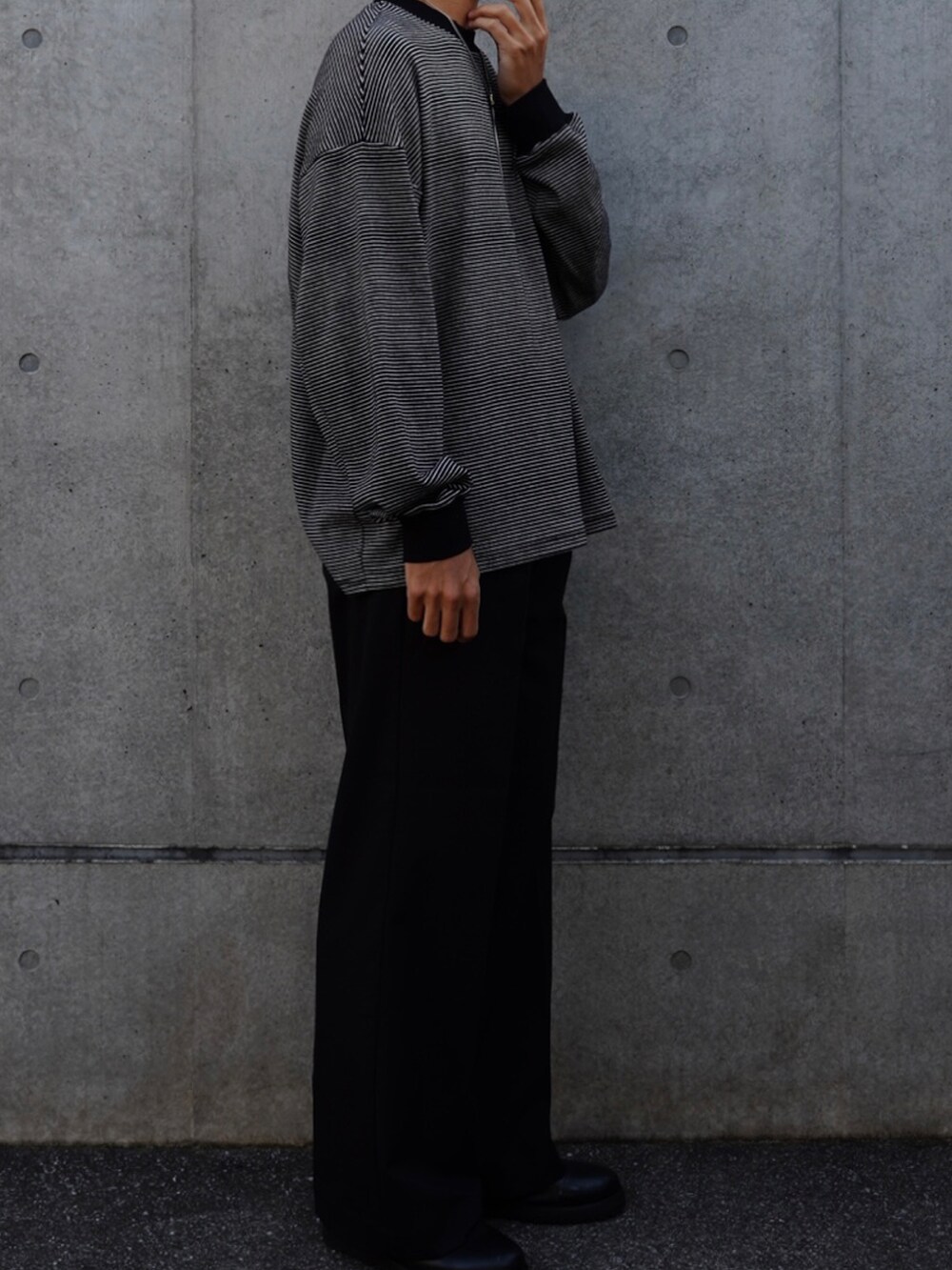 ブラック系のTシャツ/カットソー、ブラック系のスラックス、ブラック系のローファーを着用したメンズの秋コーディネートの3枚目の写真