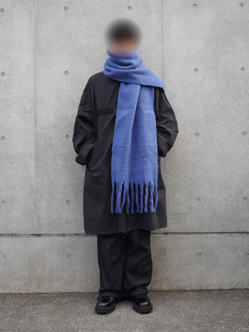 ブラック系のモッズコート、ブラック系のカーゴパンツ、ブルー系のマフラーを着用したメンズの秋コーディネートの2枚目の写真