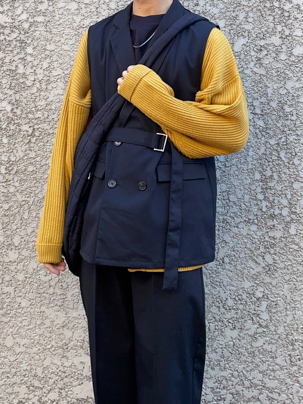 ブラック系のスラックス、ブラック系のベスト、イエロー系のカーディガン/ボレロを着用したメンズの春コーディネートの2枚目の写真