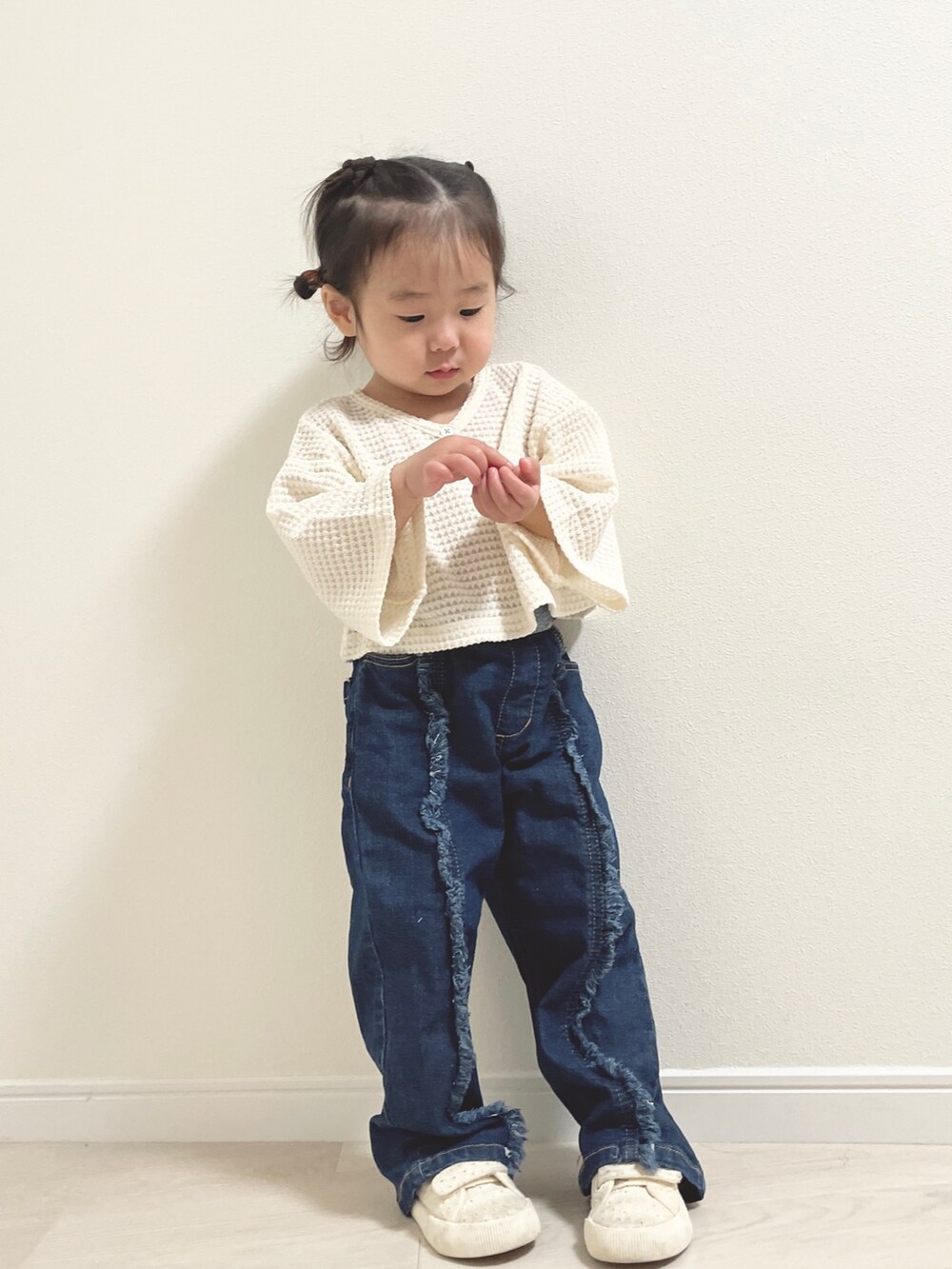 ブルー系のデニムパンツ、ホワイト系のスニーカー、ホワイト系のその他ベビーウェアを着用したキッズの冬コーディネートの3枚目の写真