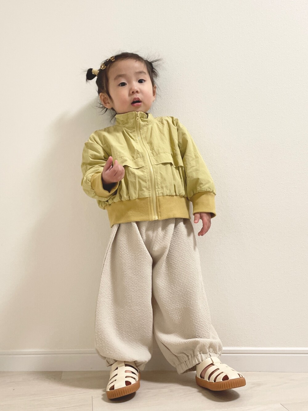 ホワイト系のサンダル、イエロー系のその他ベビーウェア、ホワイト系のその他ベビーウェアを着用したキッズの冬コーディネートの2枚目の写真