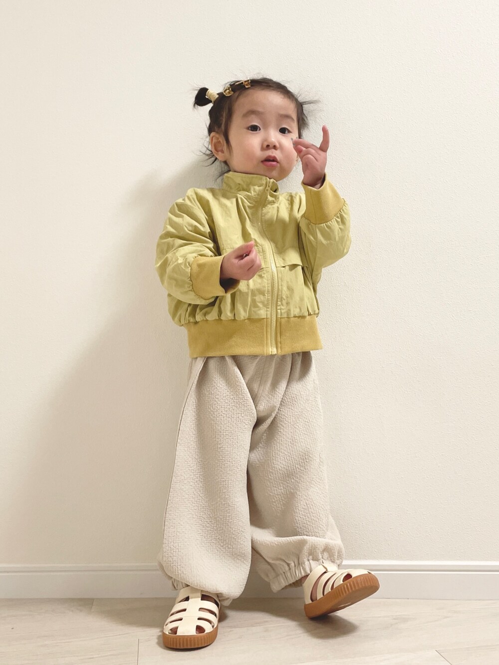 ホワイト系のサンダル、イエロー系のその他ベビーウェア、ホワイト系のその他ベビーウェアを着用したキッズの冬コーディネートの3枚目の写真