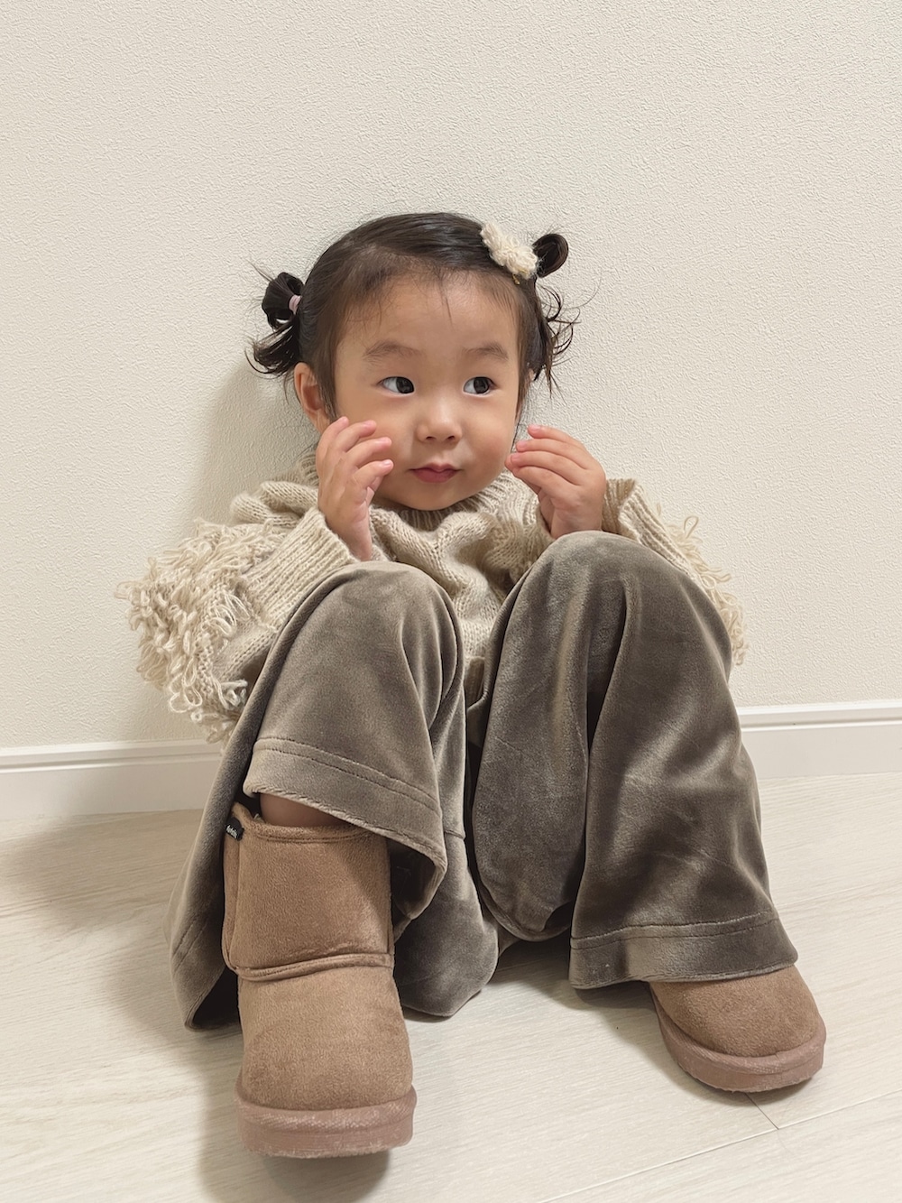 ベージュ系のニット/セーター、グリーン系のその他ベビーウェアを着用したキッズの秋コーディネートの2枚目の写真