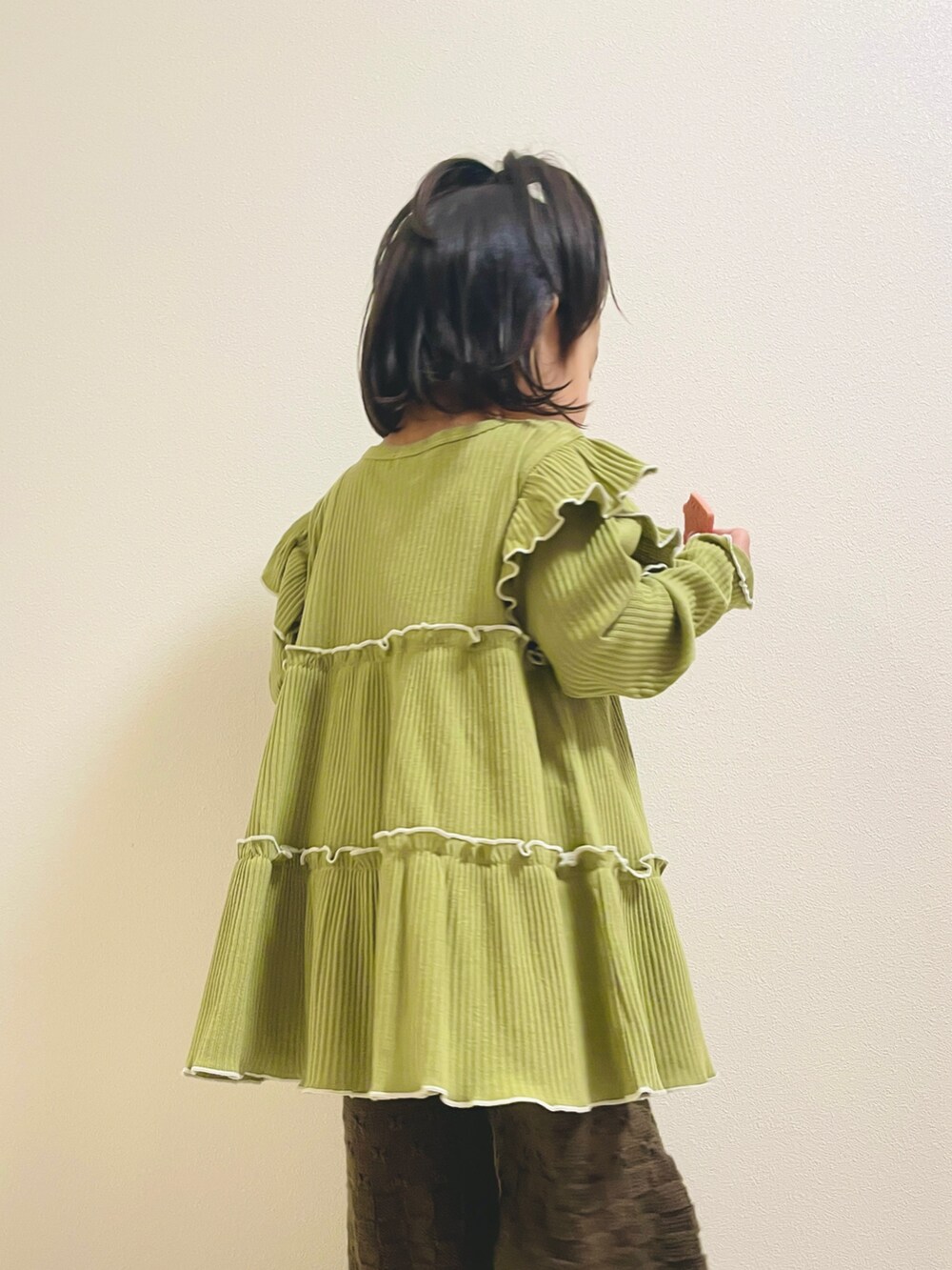 グリーン系のチュニック、ブラウン系のその他ベビーウェアを着用したキッズの秋コーディネートの2枚目の写真