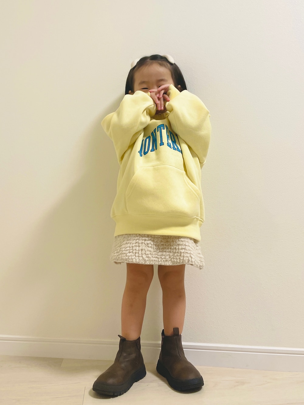 イエロー系のスウェット、ブラウン系のブーツ、ホワイト系のその他ベビーウェアを着用したキッズの秋コーディネートの3枚目の写真