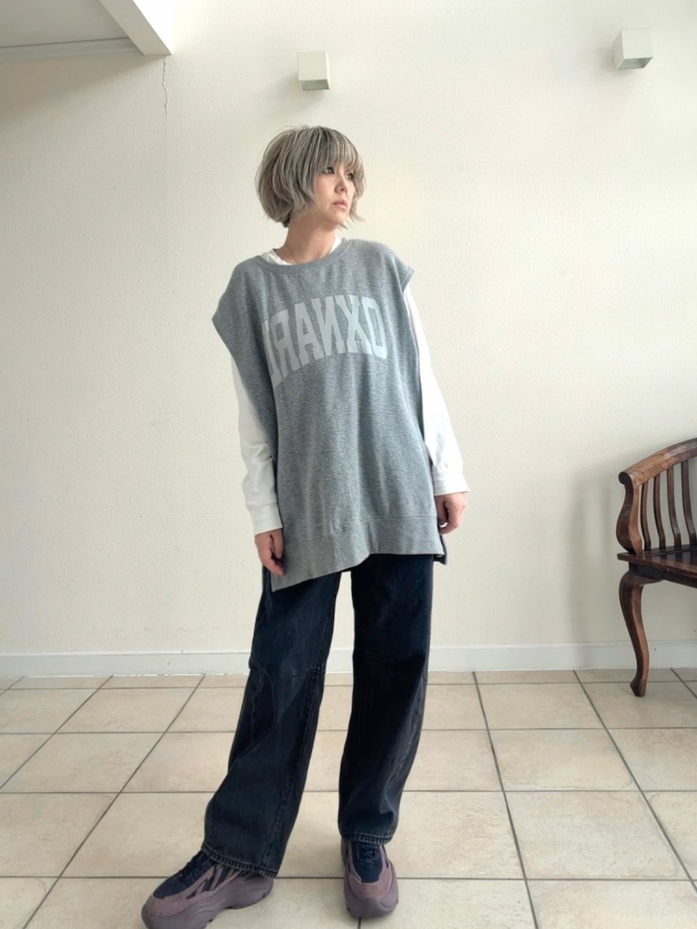 ホワイト系のTシャツ/カットソー、パープル系のスニーカー、ブラック系のデニムパンツを着用したレディースの春コーディネートの2枚目の写真