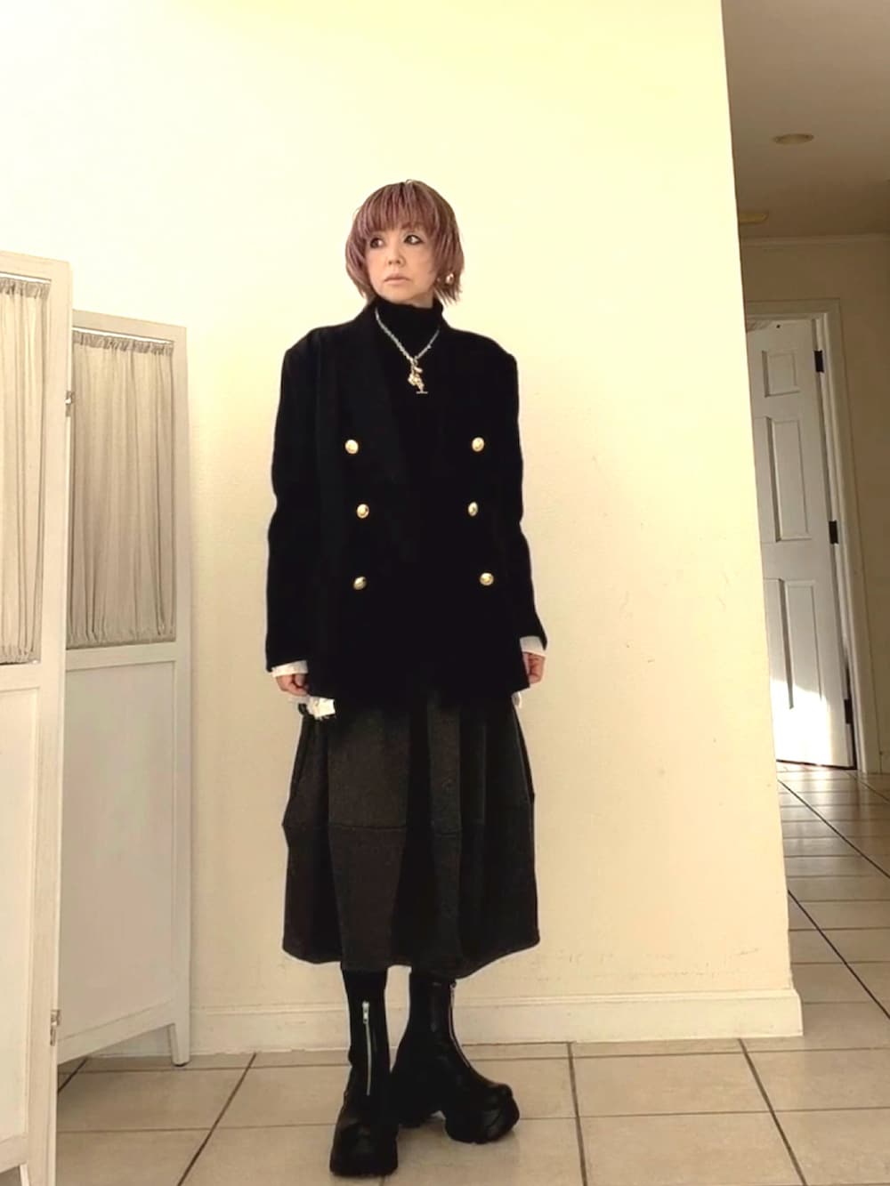 ブルー系のテーラードジャケット、ブラック系のニット/セーター、グレー系のスカートを着用したレディースの冬コーディネートの2枚目の写真