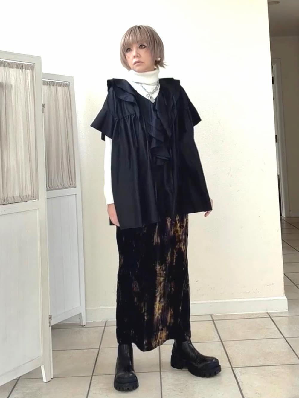 ブラック系のシャツ/ブラウス、ホワイト系のニット/セーター、パープル系のスカートを着用したレディースの冬コーディネートの2枚目の写真