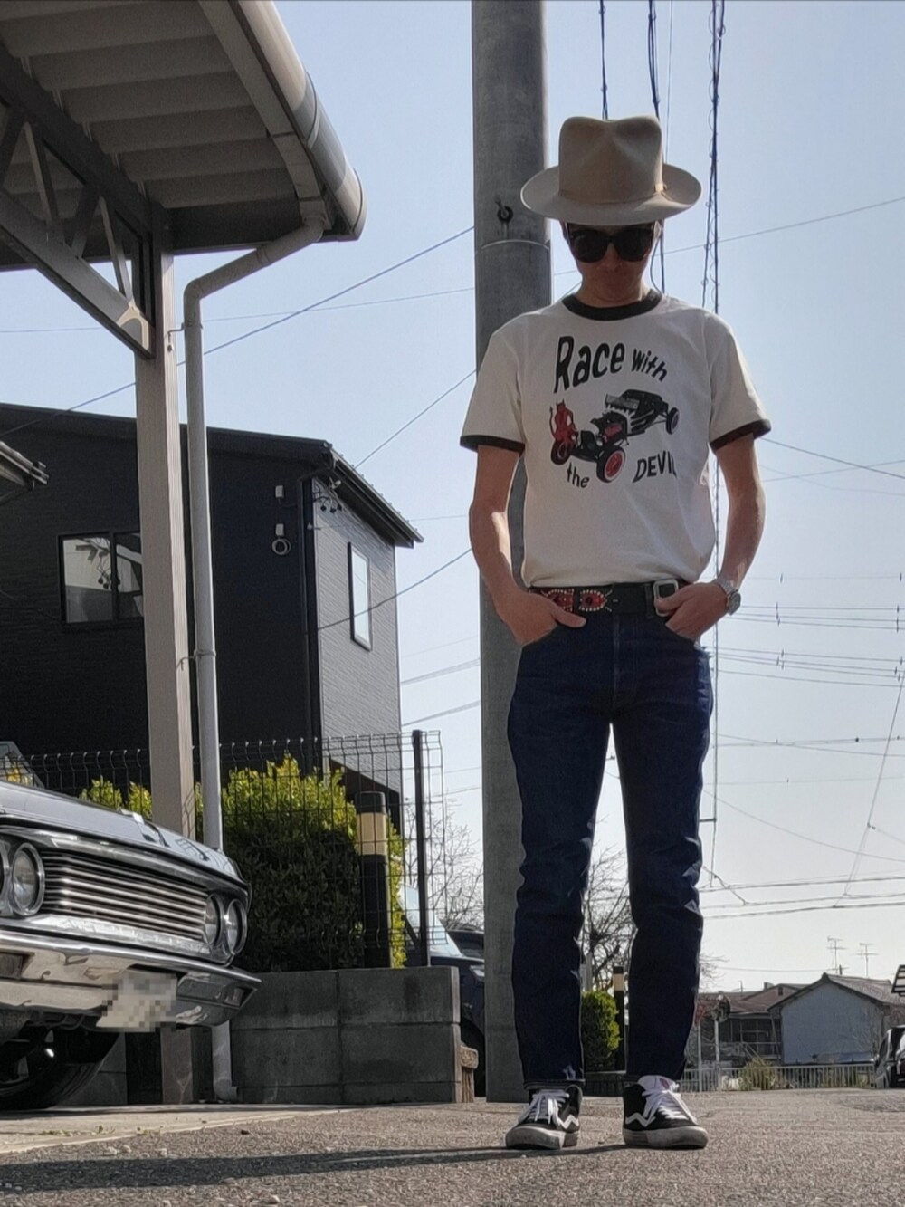 ブルー系のデニムパンツ、ホワイト系のTシャツ/カットソー、ブラック系のスニーカーを着用したメンズの春コーディネートの2枚目の写真