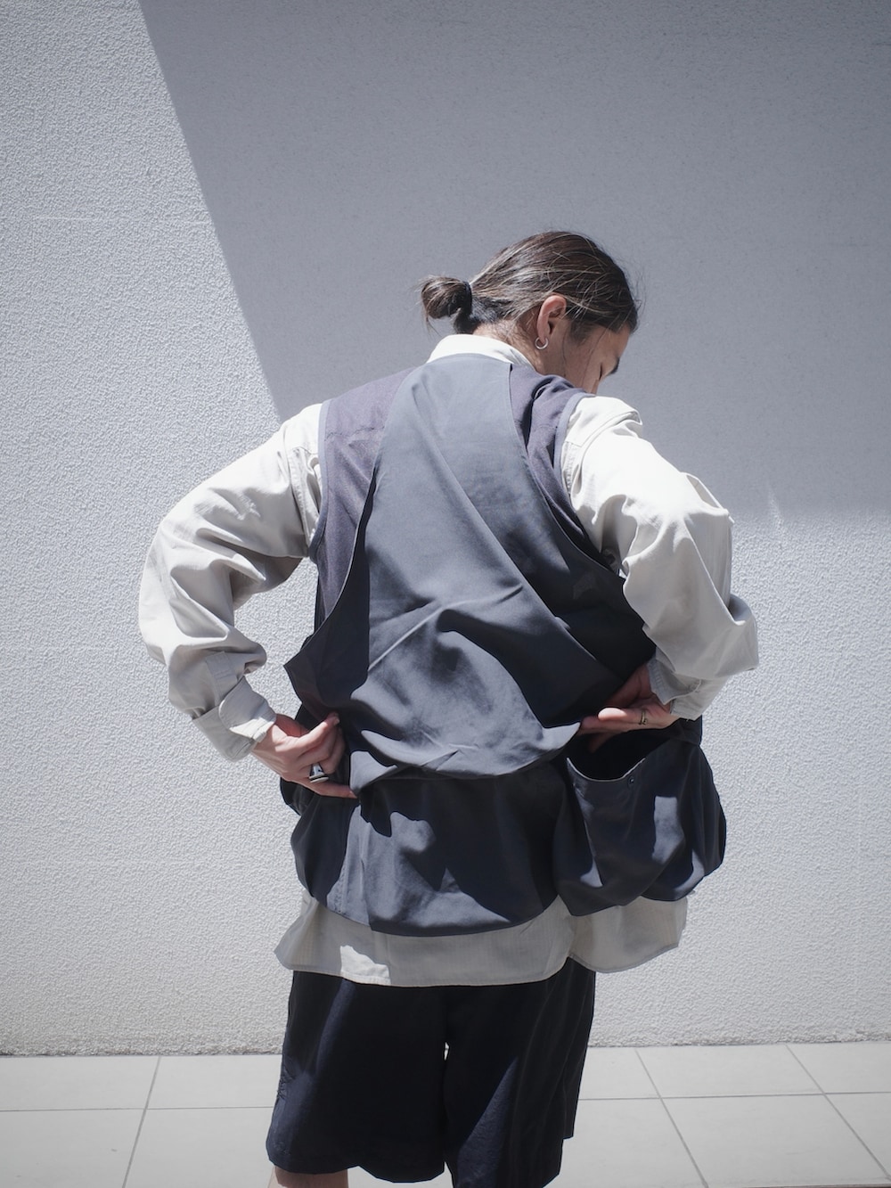 グレー系のベスト、ブラック系のその他パンツを着用したメンズの春コーディネートの5枚目の写真