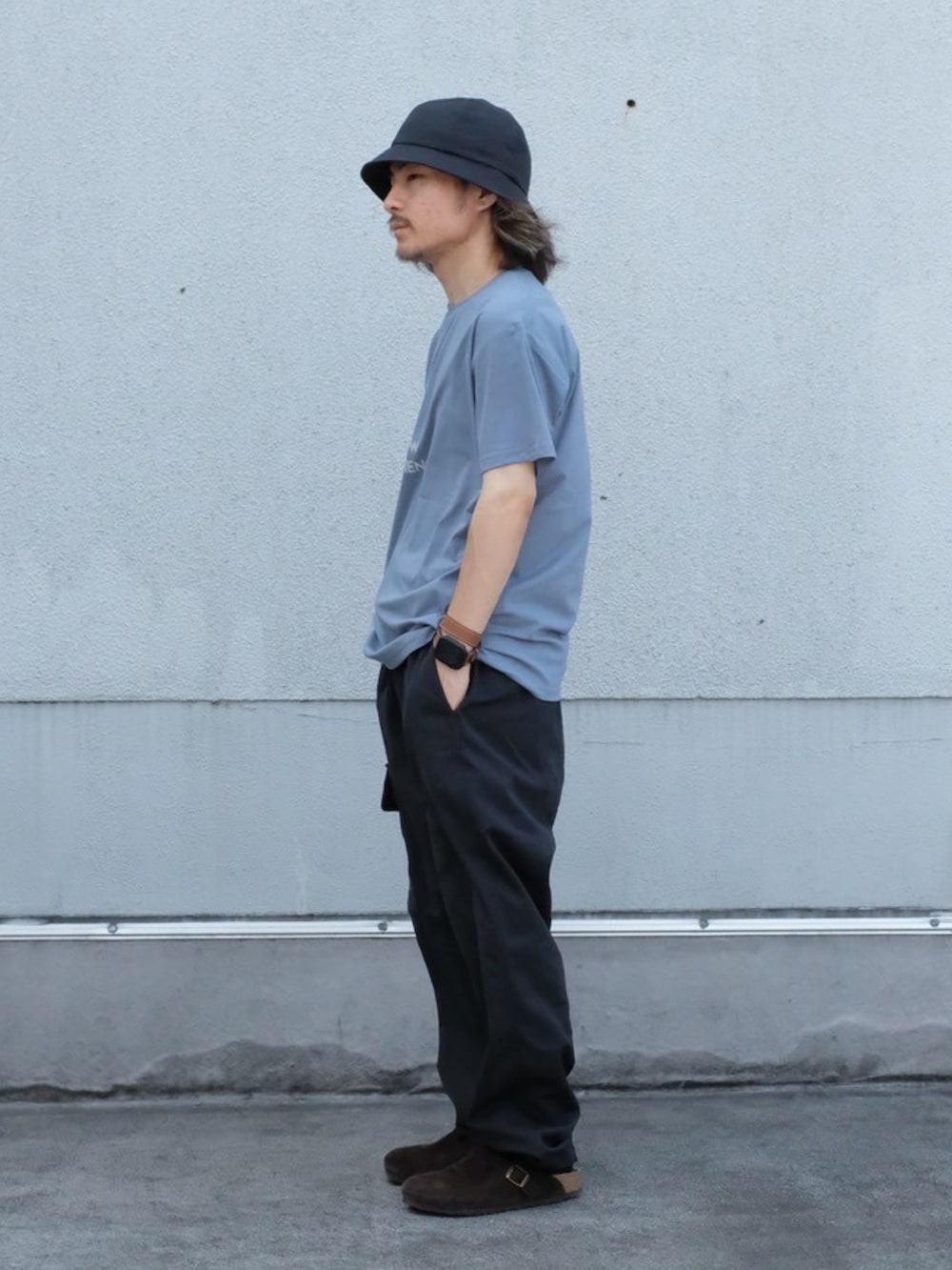 ブルー系のTシャツ/カットソー、ブラック系のカーゴパンツ、ブラック系のハットを着用したメンズの夏コーディネートの2枚目の写真