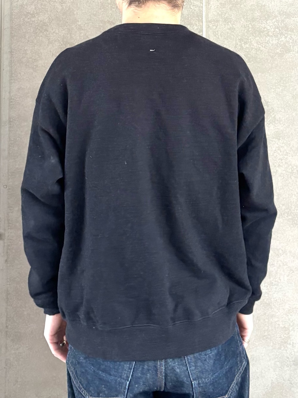 ブラック系のスウェット、ブルー系のデニムパンツ、ブラック系のバックパック/リュックを着用したメンズの冬コーディネートの9枚目の写真