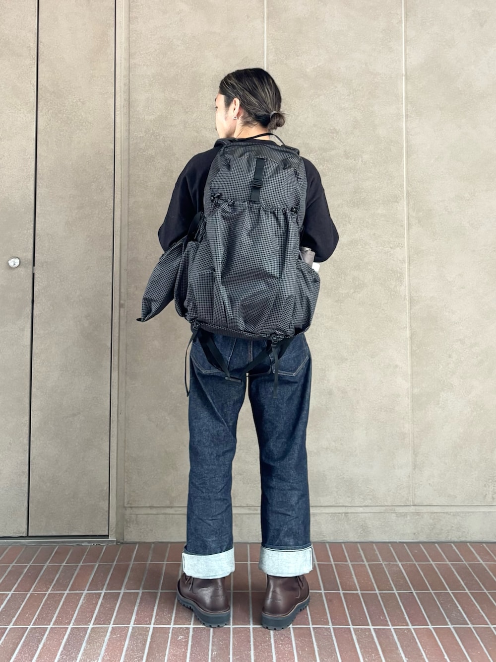 ブラック系のスウェット、ブルー系のデニムパンツ、ブラック系のバックパック/リュックを着用したメンズの冬コーディネートの3枚目の写真