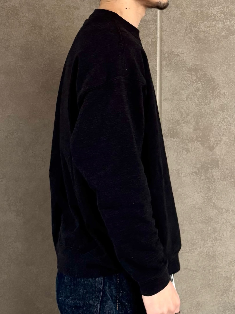 ブラック系のスウェット、ブルー系のデニムパンツ、ブラック系のバックパック/リュックを着用したメンズの冬コーディネートの8枚目の写真