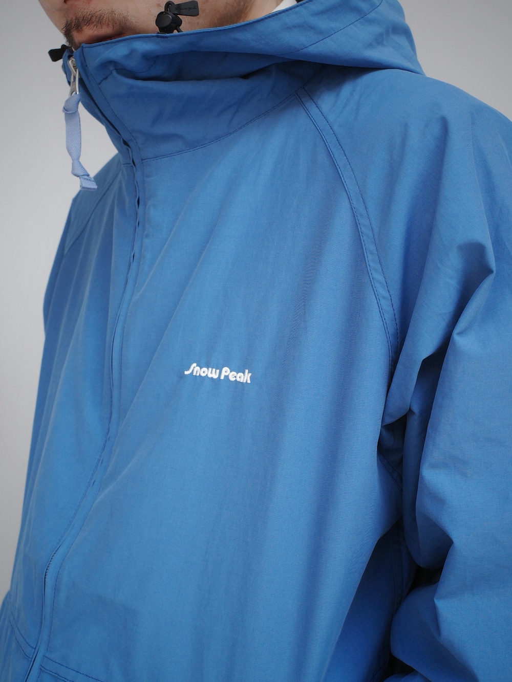 ブルー系のマウンテンパーカー、ホワイト系のシャツ/ブラウスを着用したメンズの冬コーディネートの3枚目の写真