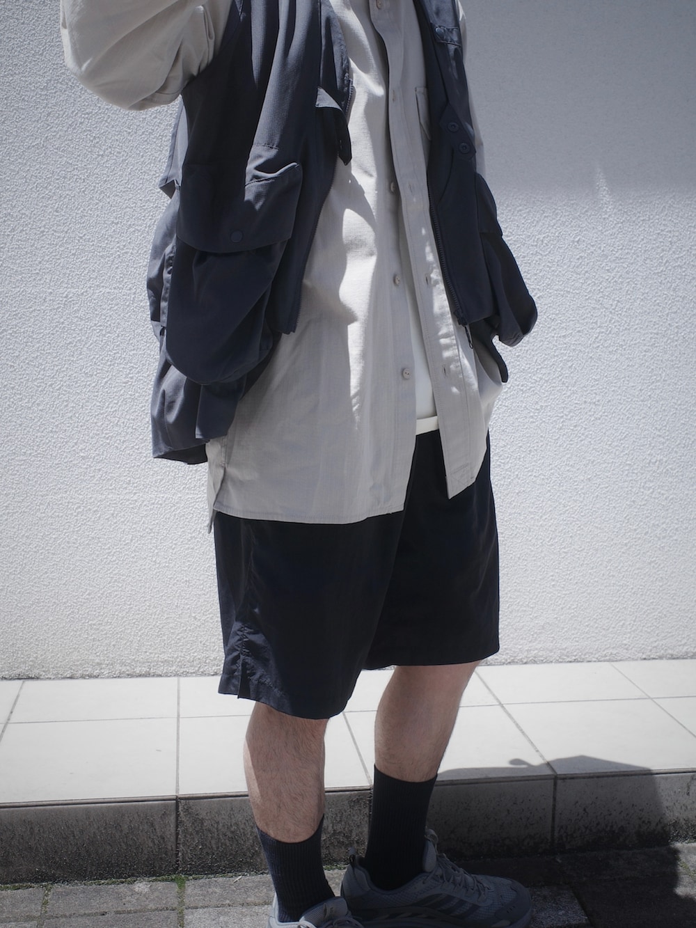 グレー系のベスト、ブラック系のその他パンツを着用したメンズの春コーディネートの6枚目の写真