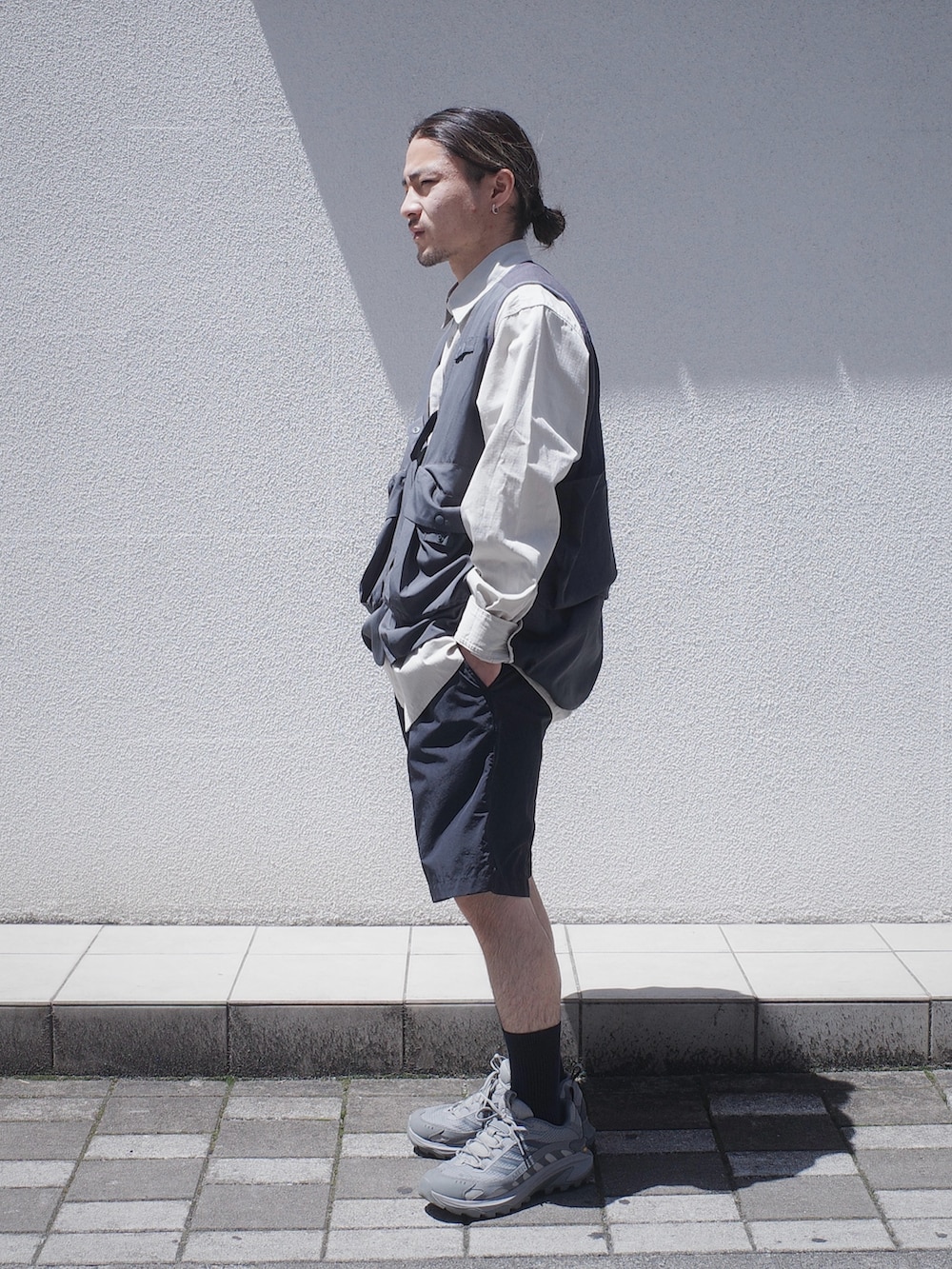 グレー系のベスト、ブラック系のその他パンツを着用したメンズの春コーディネートの2枚目の写真