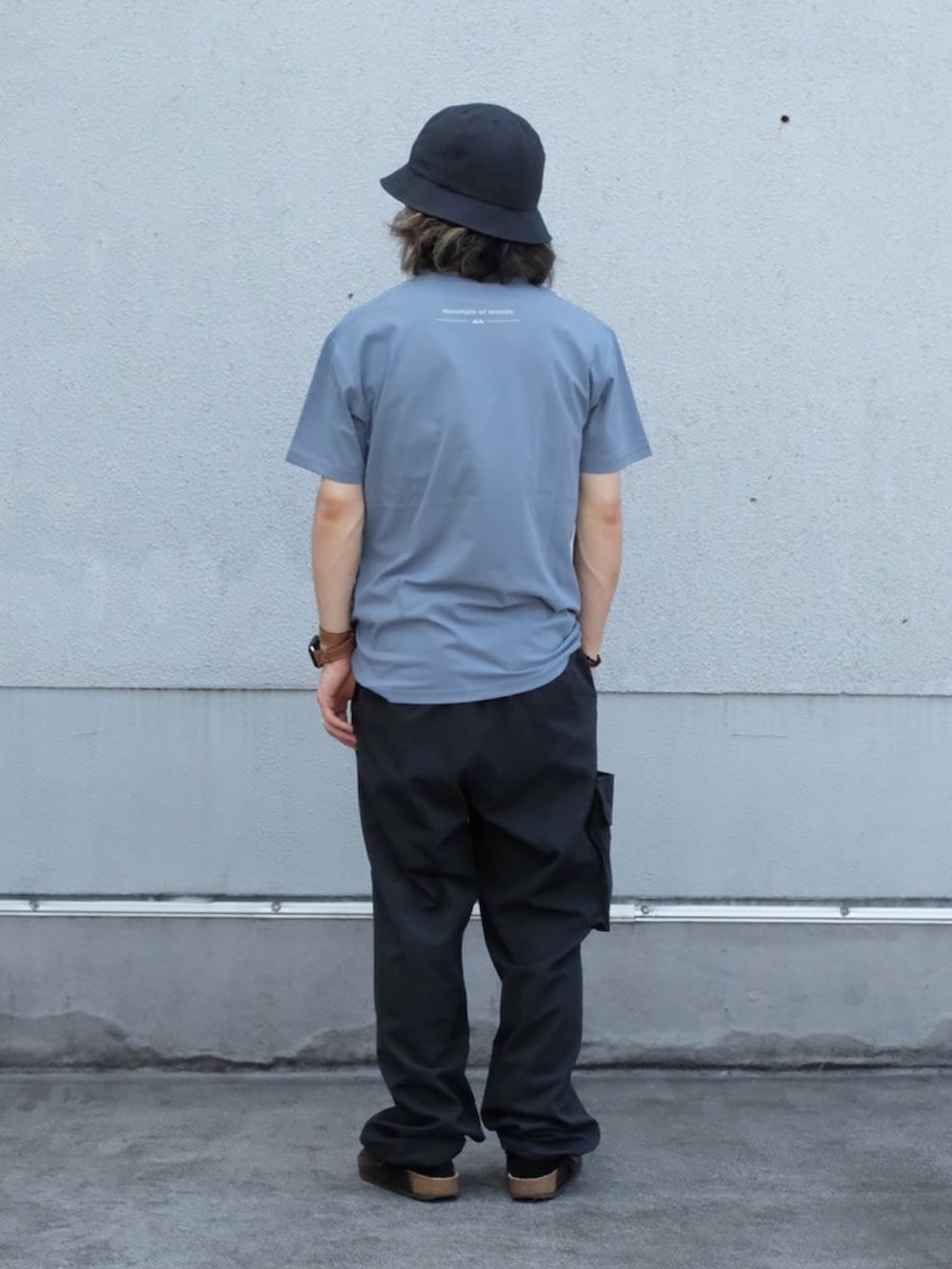 ブルー系のTシャツ/カットソー、ブラック系のカーゴパンツ、ブラック系のハットを着用したメンズの夏コーディネートの3枚目の写真