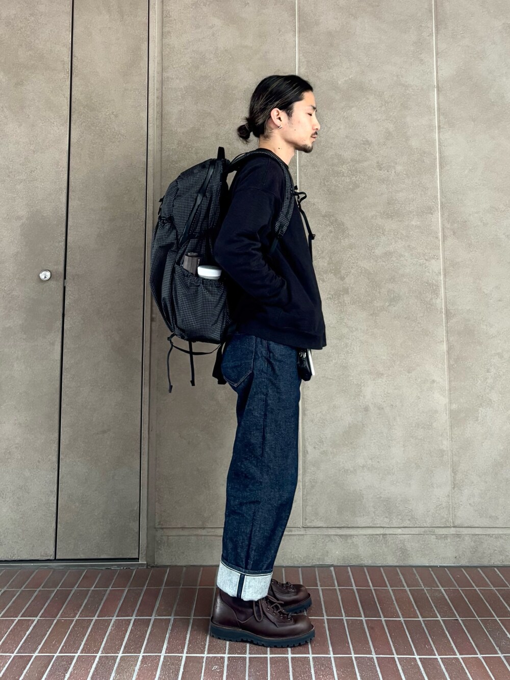 ブラック系のスウェット、ブルー系のデニムパンツ、ブラック系のバックパック/リュックを着用したメンズの冬コーディネートの2枚目の写真