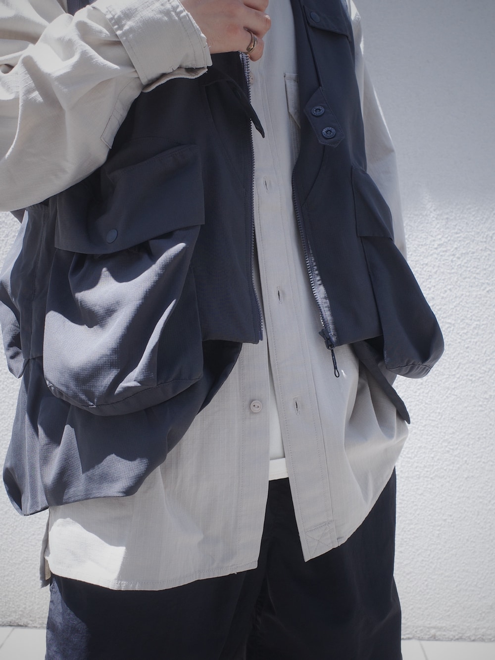 グレー系のベスト、ブラック系のその他パンツを着用したメンズの春コーディネートの7枚目の写真