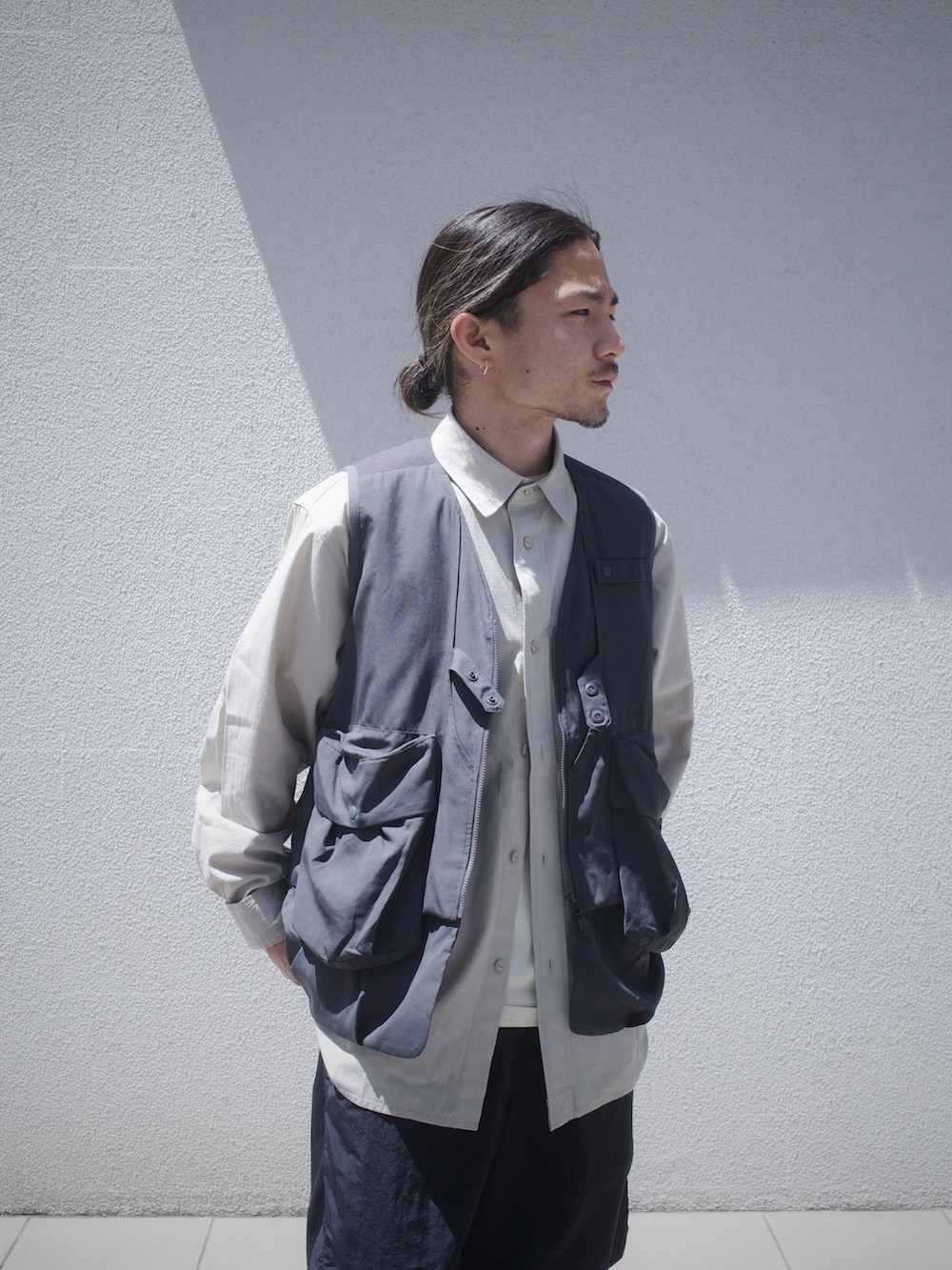 グレー系のベスト、ブラック系のその他パンツを着用したメンズの春コーディネートの4枚目の写真