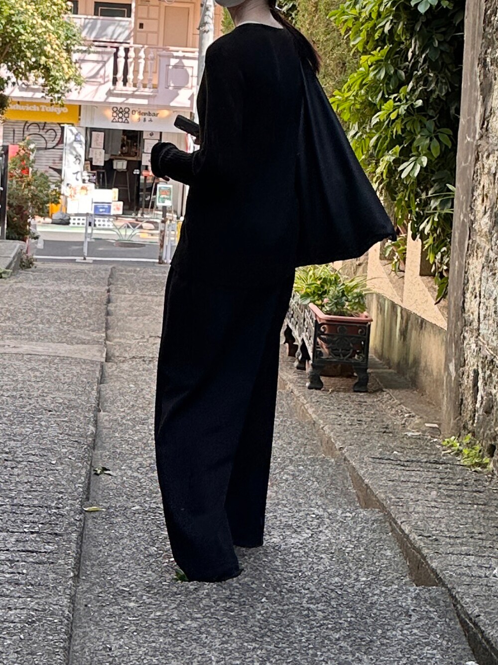 ブラック系のトートバッグ、ブラック系のカーディガン/ボレロ、ブラック系のその他パンツを着用したレディースの春コーディネートの2枚目の写真