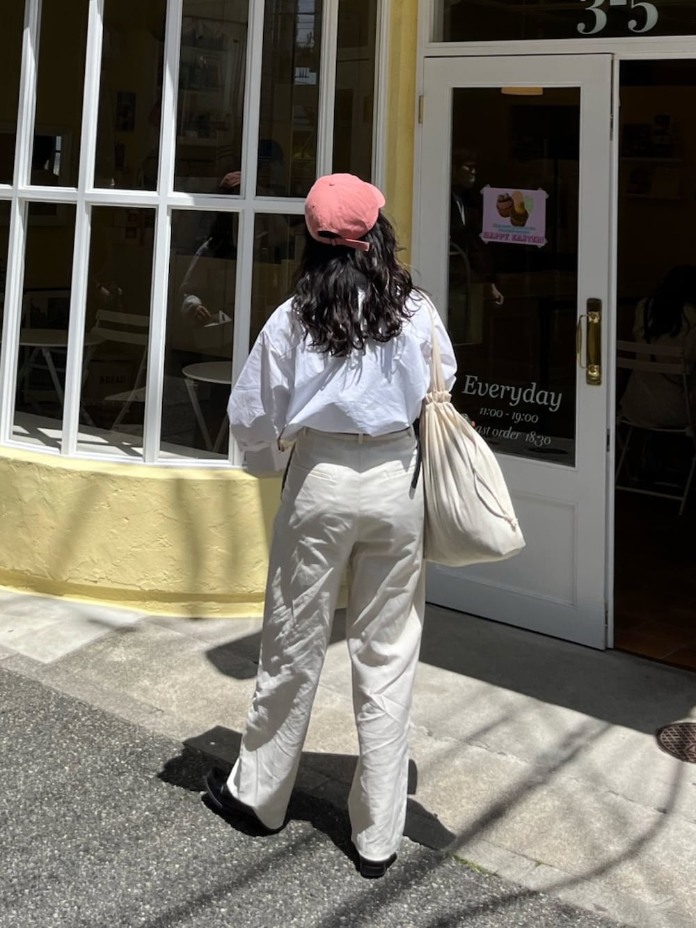 ホワイト系のシャツ/ブラウス、ホワイト系のパンツ、グリーン系のボストンバッグを着用したレディースの秋コーディネートの2枚目の写真