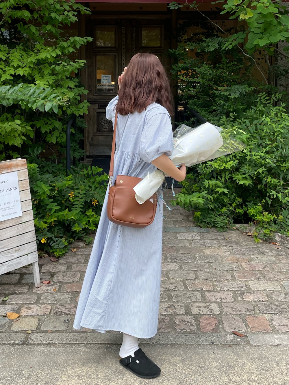 ブルー系のシャツワンピース、ブラック系のサンダル、ブラウン系のショルダーバッグを着用したレディースの夏コーディネートの3枚目の写真