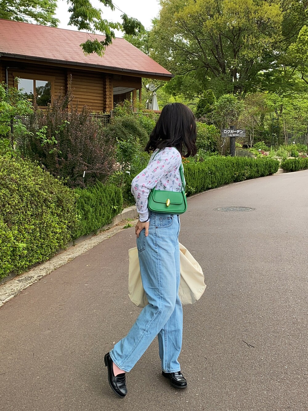 ホワイト系のTシャツ/カットソー、グリーン系のショルダーバッグ、ブルー系のデニムパンツを着用したレディースの春コーディネートの2枚目の写真