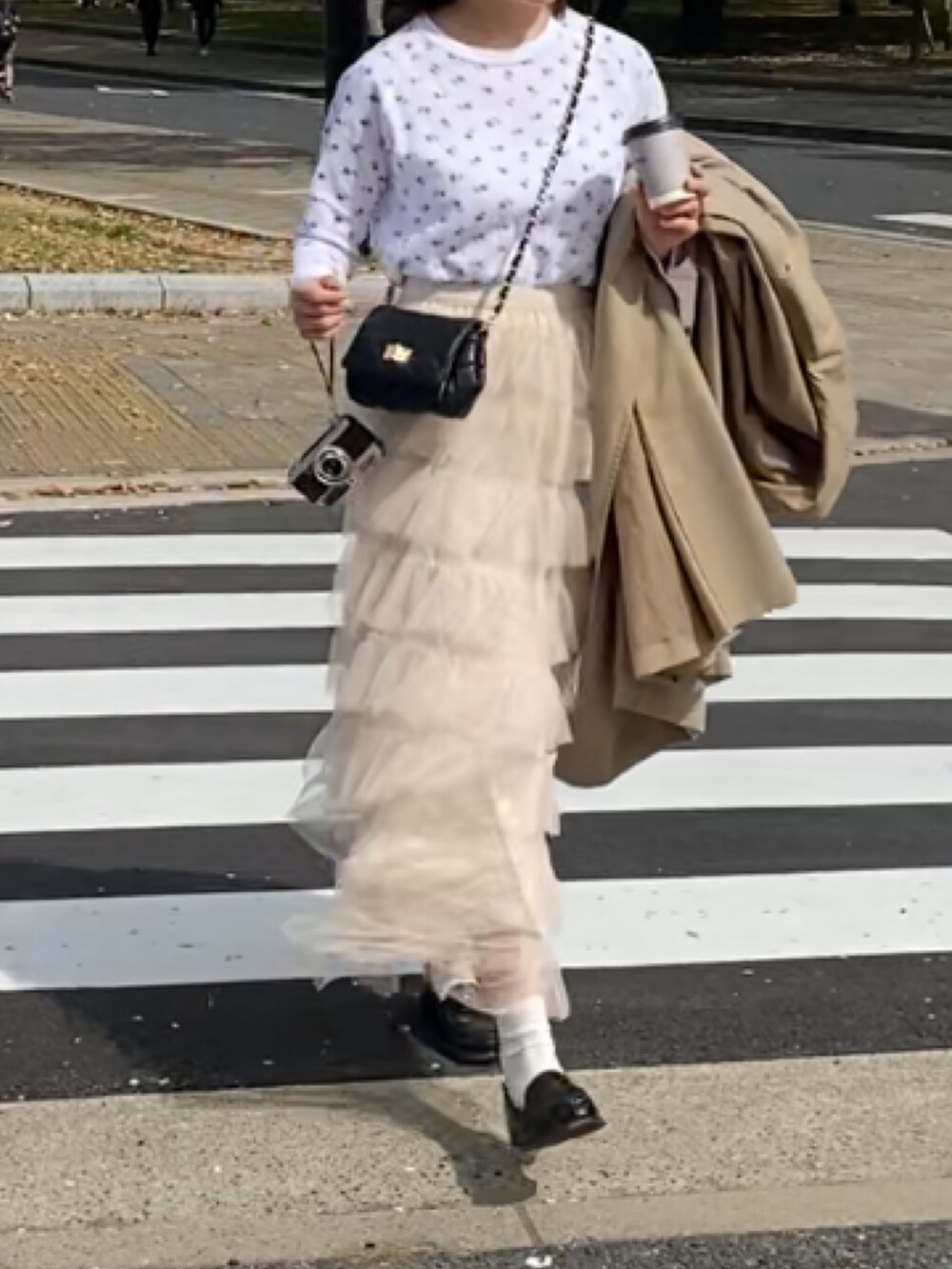 ホワイト系のTシャツ/カットソー、ホワイト系のスカート、ブラック系のショルダーバッグを着用したレディースの春コーディネートの2枚目の写真