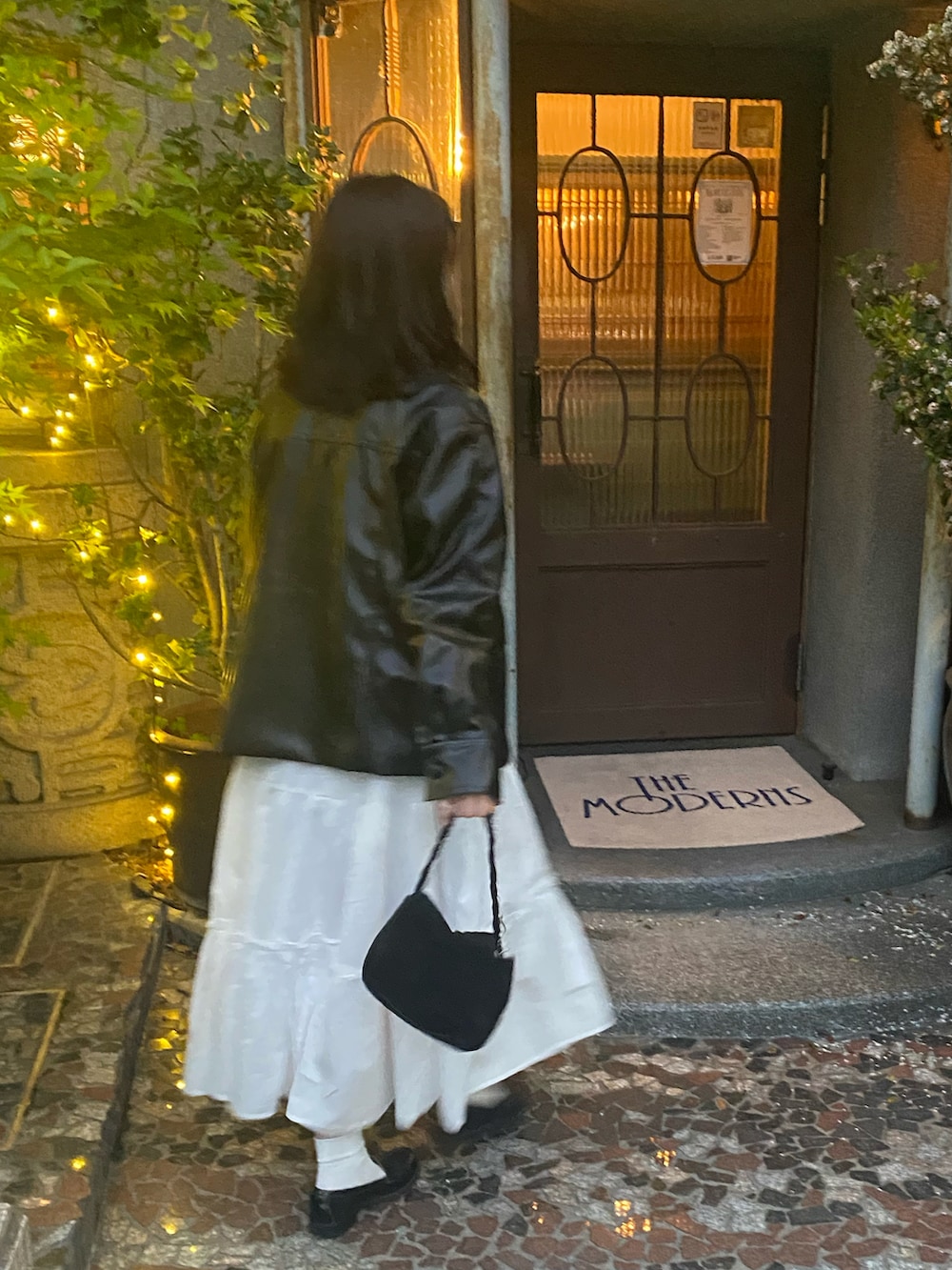 ブラック系のその他アウター、ホワイト系のTシャツ/カットソー、ブラック系のショルダーバッグを着用したレディースの春コーディネートの2枚目の写真