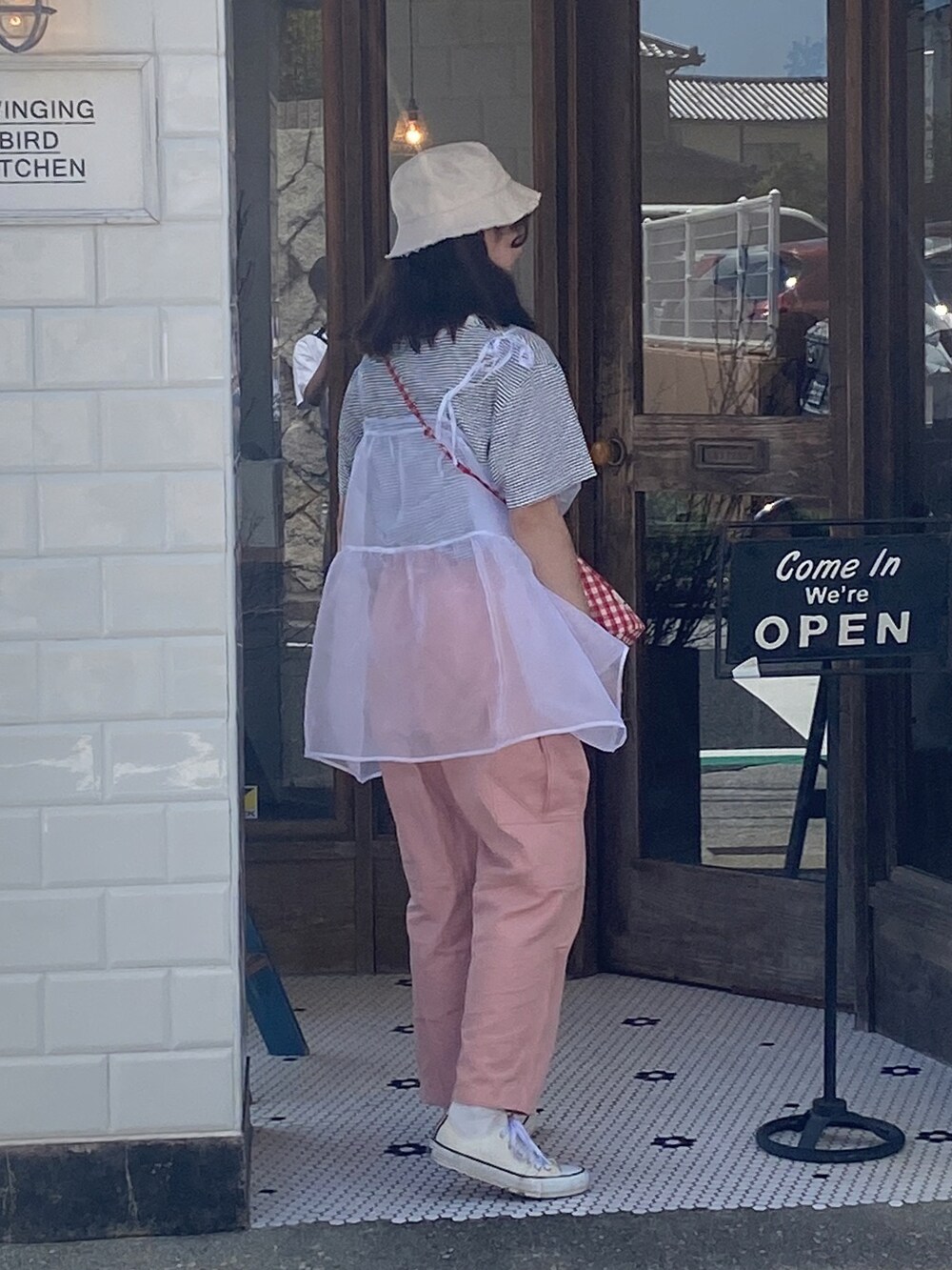 ピンク系のカーゴパンツ、ホワイト系のワンピース、ホワイト系のスニーカーを着用したレディースの夏コーディネートの3枚目の写真