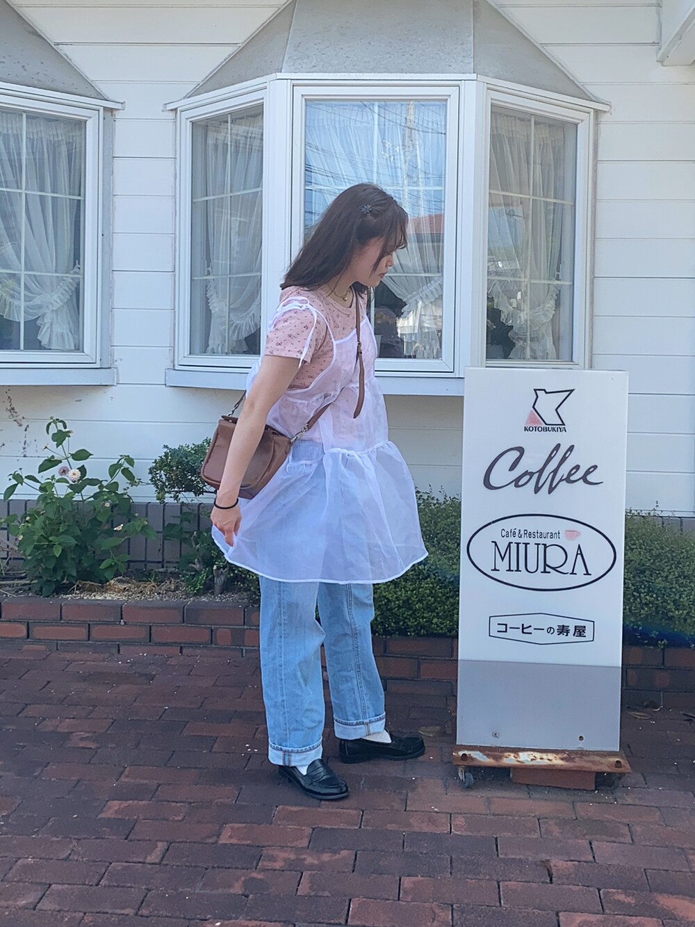 ピンク系のTシャツ/カットソー、ホワイト系のワンピース、ブルー系のデニムパンツを着用したレディースの夏コーディネートの2枚目の写真
