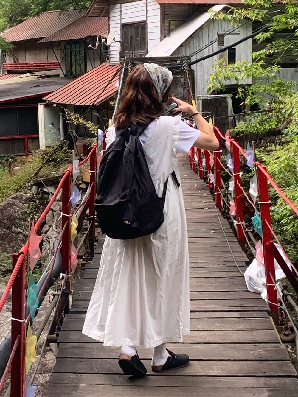 ホワイト系のワンピース、ホワイト系のTシャツ/カットソー、ブラック系のサンダルを着用したレディースの秋コーディネートの4枚目の写真