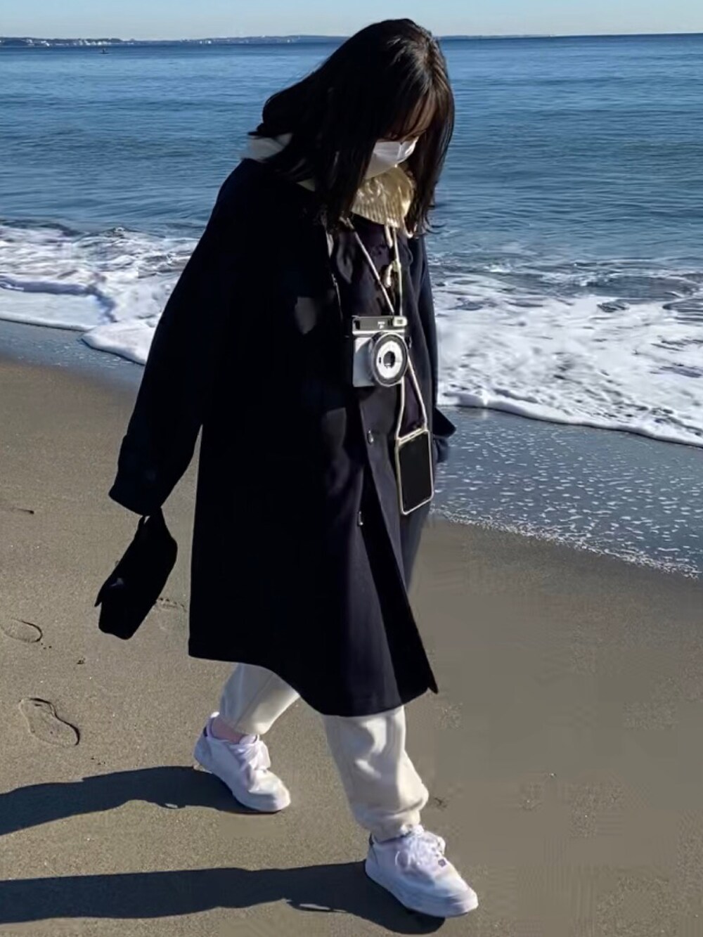 ブラック系のピーコート、ホワイト系のスウェットパンツ、レッド系のスニーカーを着用したレディースの冬コーディネートの2枚目の写真