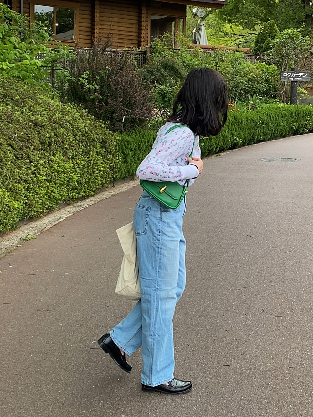 ホワイト系のTシャツ/カットソー、グリーン系のショルダーバッグ、ブルー系のデニムパンツを着用したレディースの春コーディネートの3枚目の写真