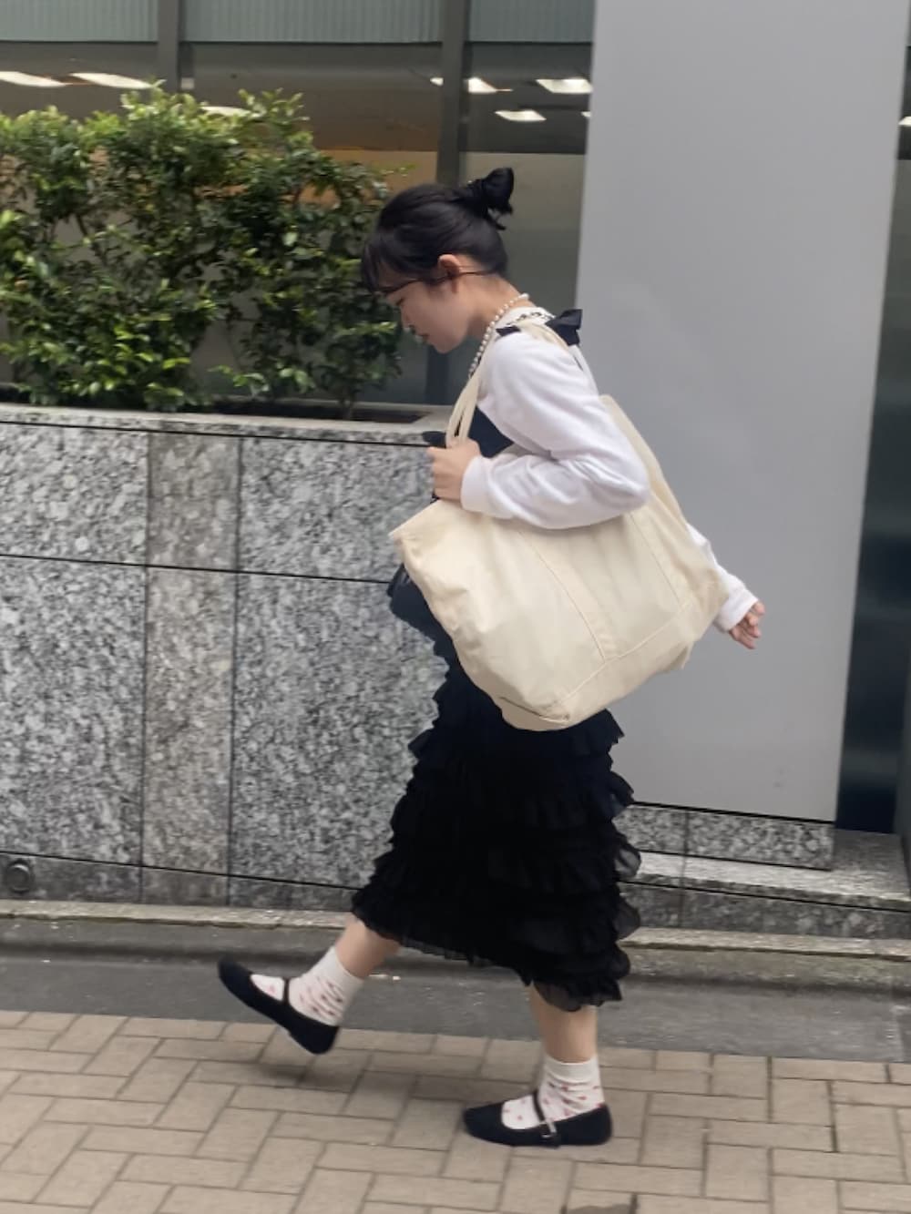 ブラック系のショルダーバッグ、ブラック系のワンピース、ホワイト系のTシャツ/カットソーを着用したレディースの春コーディネートの3枚目の写真