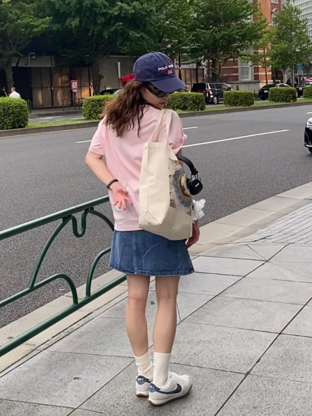 ホワイト系のスニーカー、ホワイト系のハンドバッグ、ピンク系のTシャツ/カットソーを着用したレディースの夏コーディネートの2枚目の写真