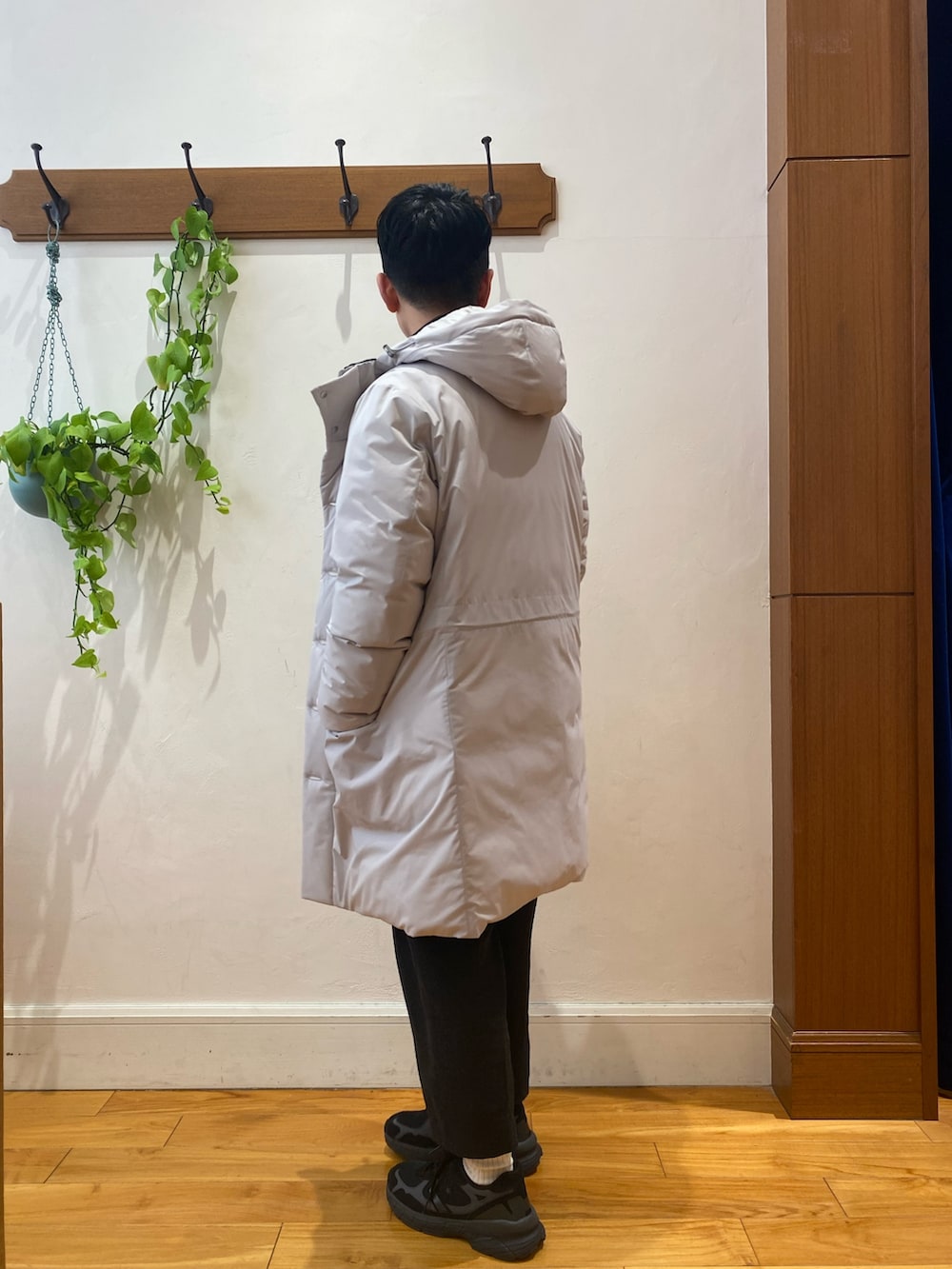 グレー系のダウンジャケット/コート、ブラック系のカーディガン/ボレロ、ブラック系のスニーカーを着用したメンズの冬コーディネートの3枚目の写真