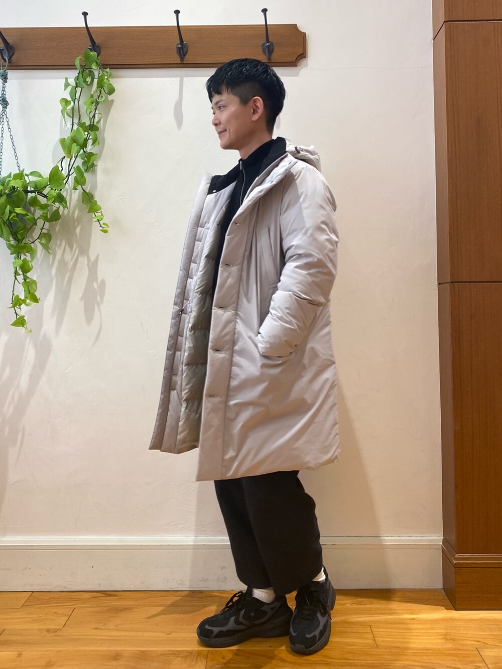 グレー系のダウンジャケット/コート、ブラック系のカーディガン/ボレロ、ブラック系のスニーカーを着用したメンズの冬コーディネートの2枚目の写真