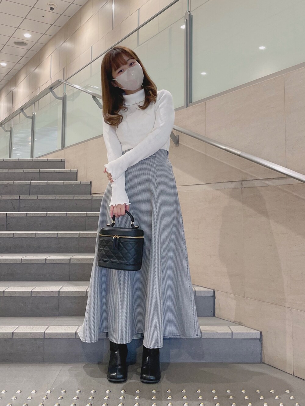 ホワイト系のニット/セーター、ブラック系のその他シューズ、その他のスカートを着用したレディースの冬コーディネートの2枚目の写真