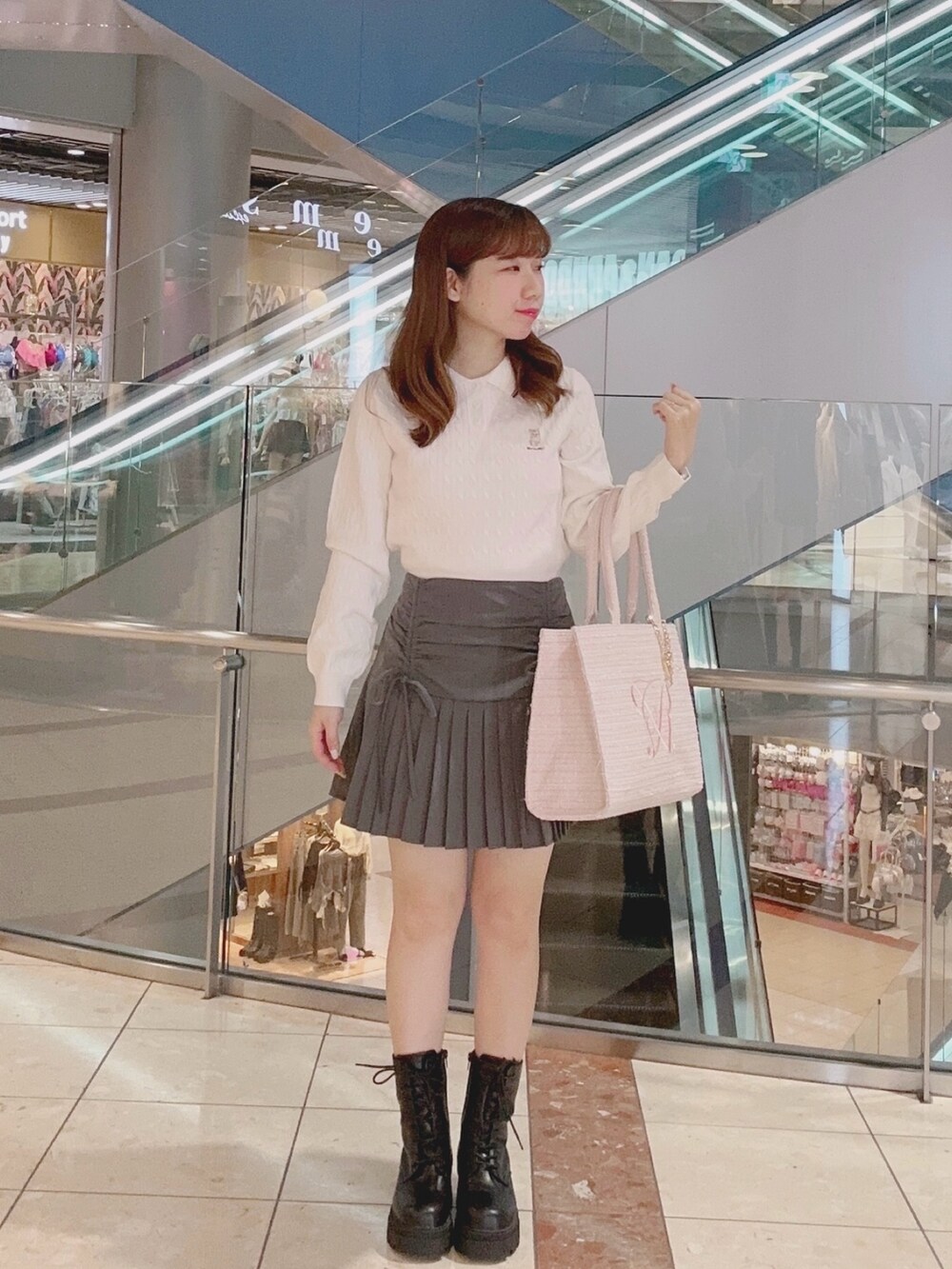 ホワイト系のニット/セーター、グレー系のスカート、ピンク系のトートバッグを着用したレディースの秋コーディネートの2枚目の写真