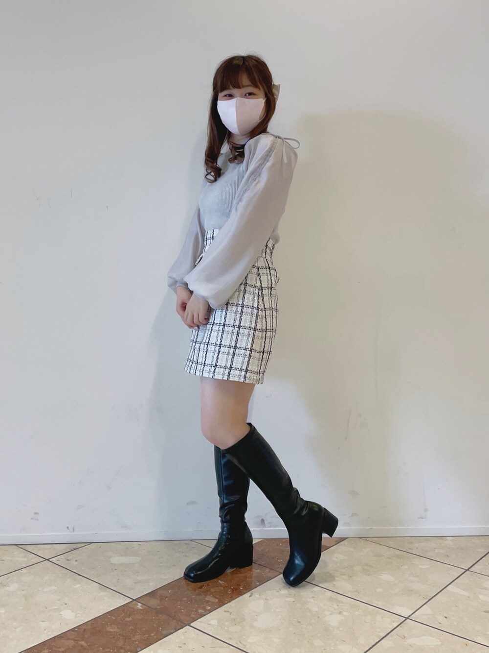 グレー系のニット/セーター、ホワイト系のスカート、ブラック系のその他シューズを着用したレディースの冬コーディネートの3枚目の写真