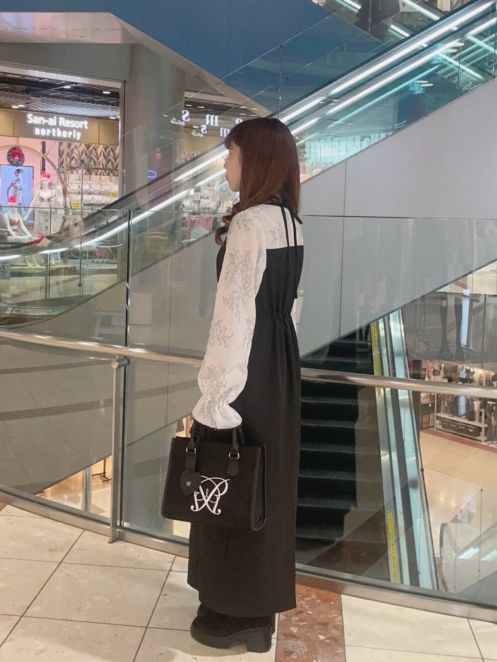 ホワイト系のドレス、ブラック系のトートバッグを着用したレディースの冬コーディネートの4枚目の写真