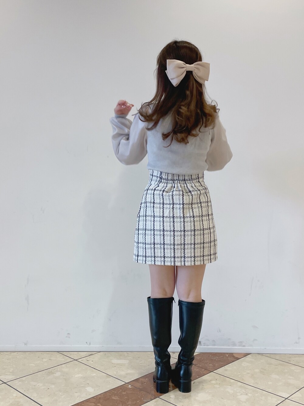 グレー系のニット/セーター、ホワイト系のスカート、ブラック系のその他シューズを着用したレディースの冬コーディネートの4枚目の写真