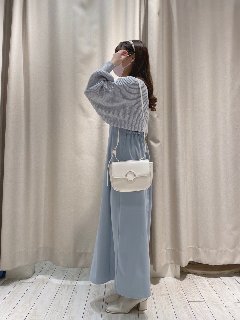ホワイト系のショルダーバッグ、ブルー系のワンピースを着用したレディースの冬コーディネートの4枚目の写真