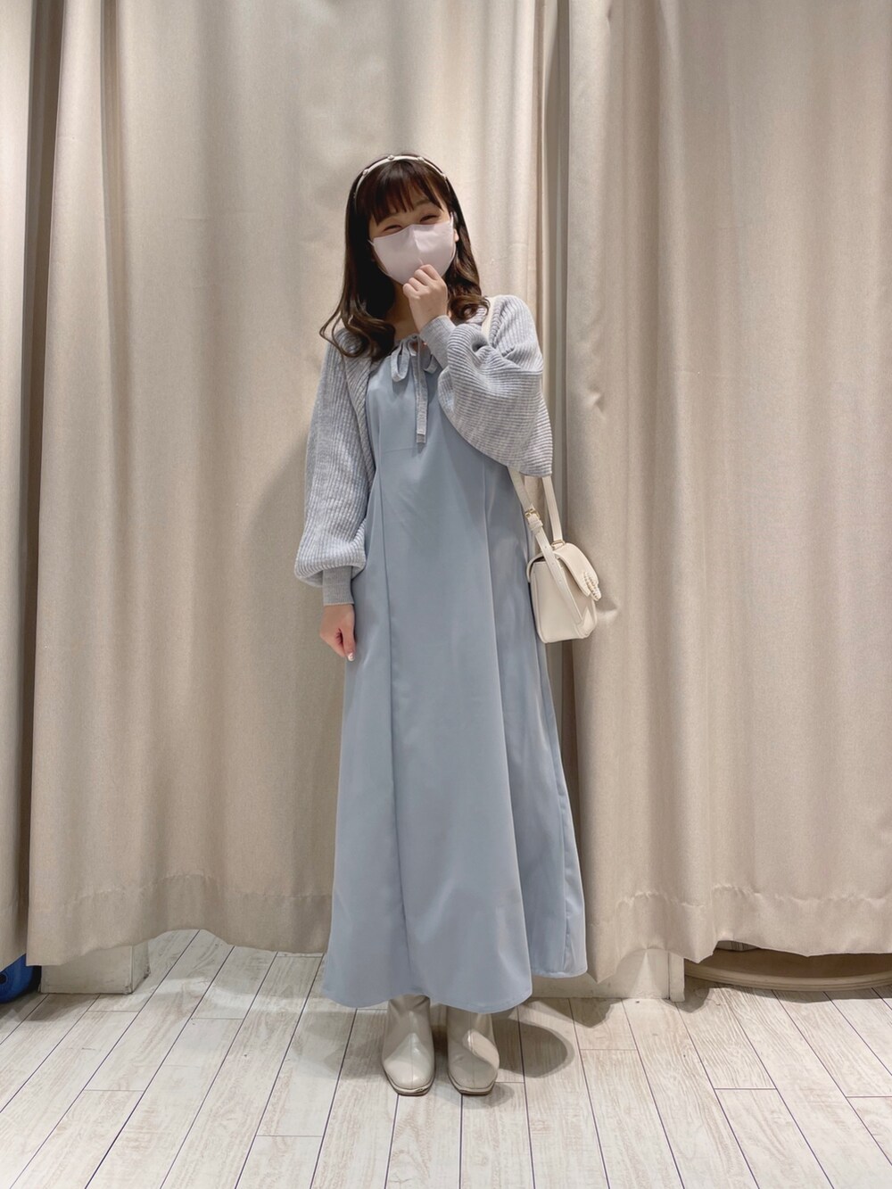 ホワイト系のショルダーバッグ、ブルー系のワンピースを着用したレディースの冬コーディネートの5枚目の写真