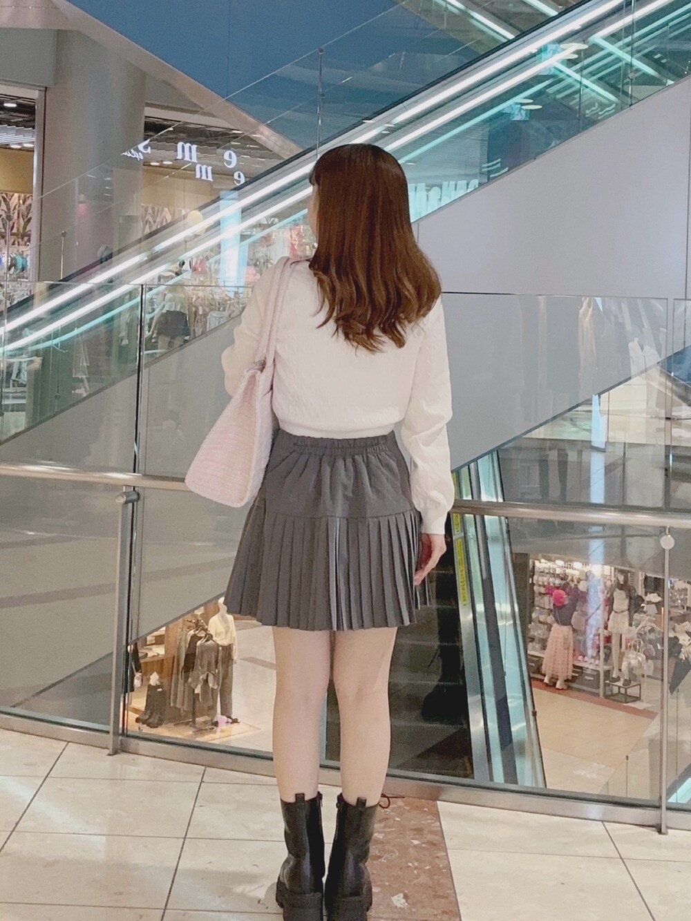 ホワイト系のニット/セーター、グレー系のスカート、ピンク系のトートバッグを着用したレディースの秋コーディネートの3枚目の写真