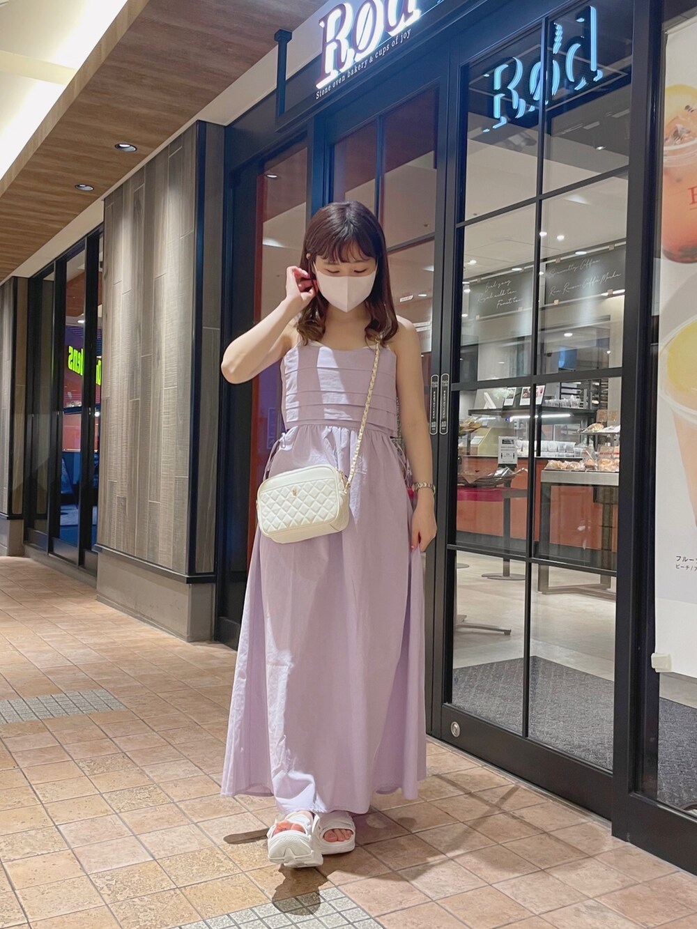 パープル系のワンピース、ホワイト系のショルダーバッグ、ホワイト系のサンダルを着用したレディースの夏コーディネートの3枚目の写真