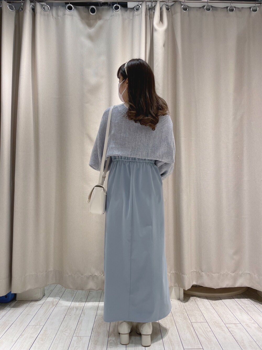 ホワイト系のショルダーバッグ、ブルー系のワンピースを着用したレディースの冬コーディネートの6枚目の写真